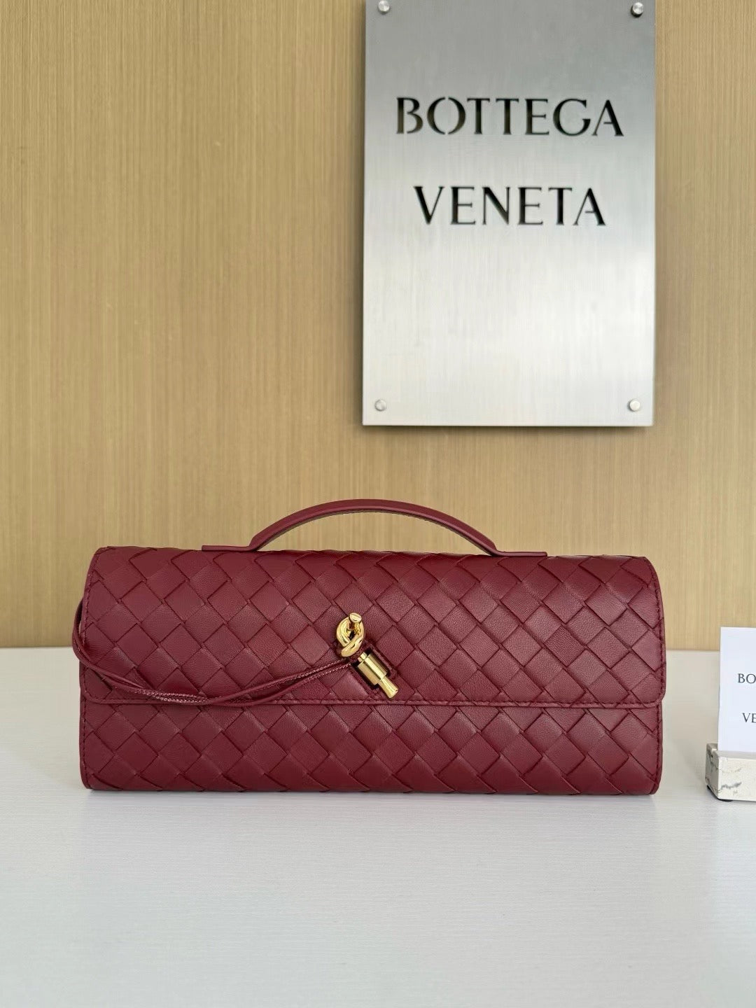 Rolled Woven Leather Clutch with Top Handle and Gold Accent